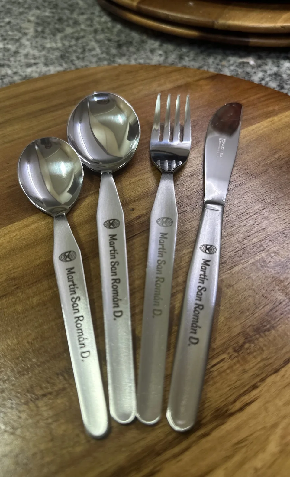 Cucharas y tenedores personalizados sobre una tabla de madera